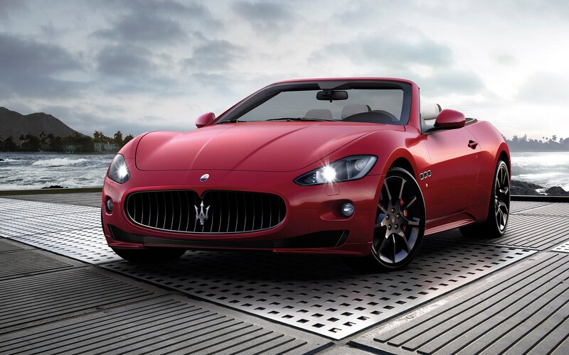 Red Maserati convertible by the sea