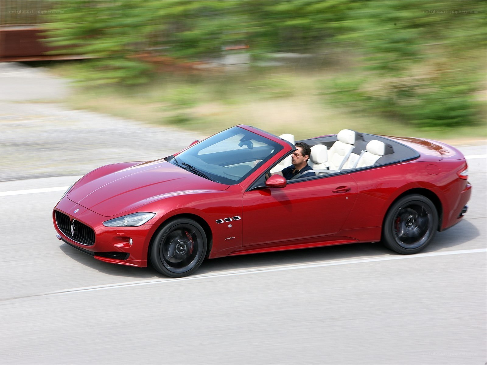 Red Maserati convertible in motion