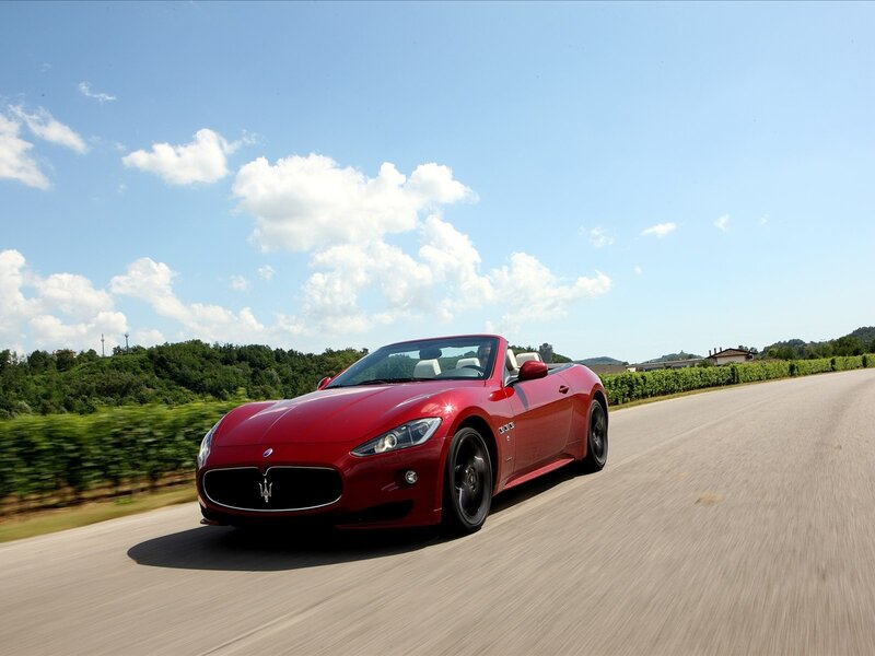 Red Maserati convertible on a country road