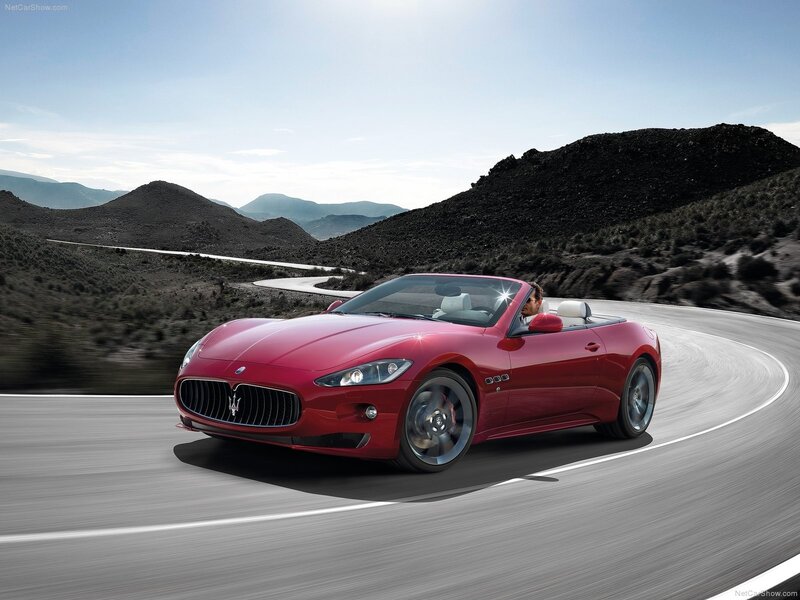 Red Maserati convertible on winding road