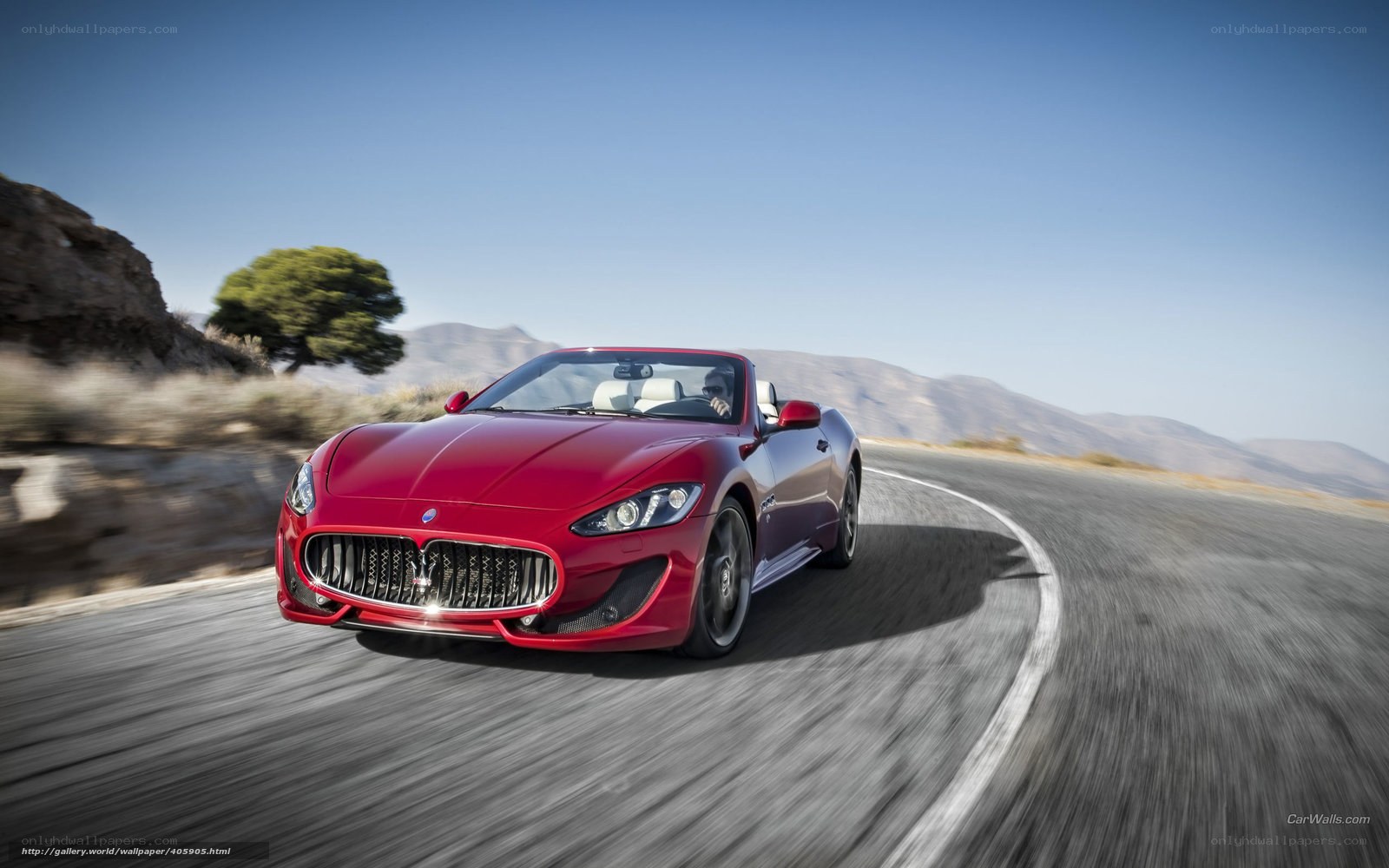 Red Maserati convertible on winding road