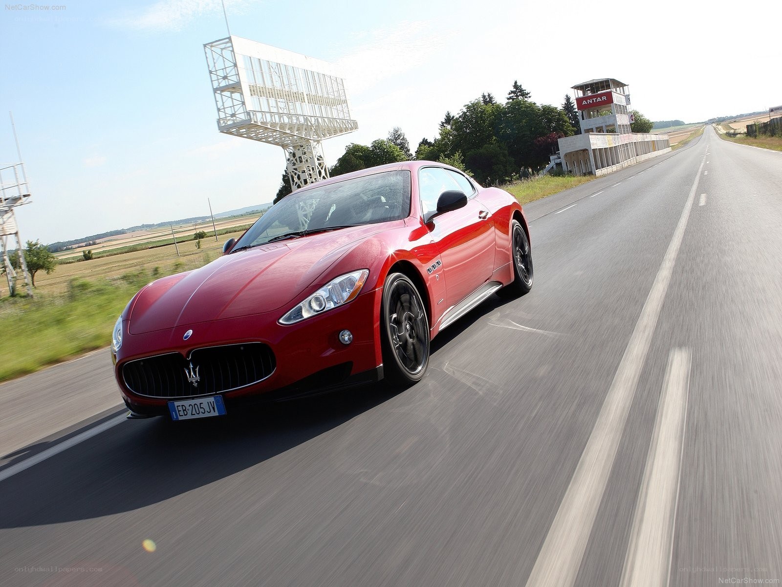 Red Maserati driving on a track