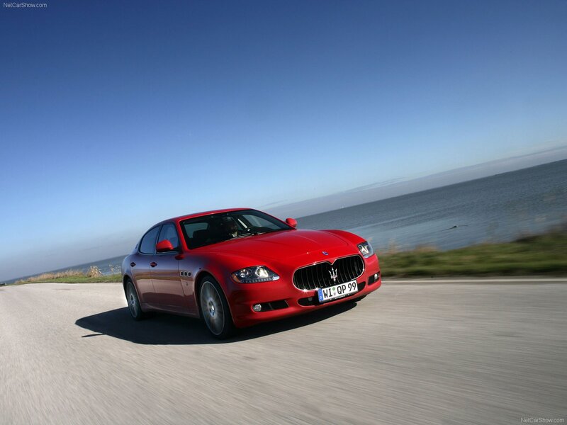 Red Maserati driving on coastal road