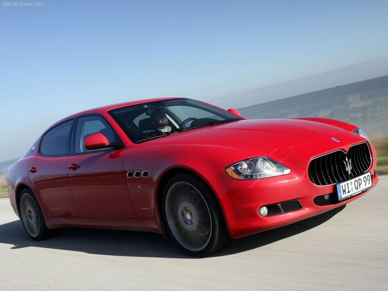red maserati driving on coastal road