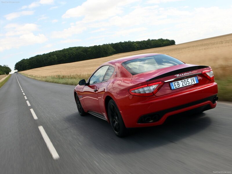 Red Maserati driving on country road