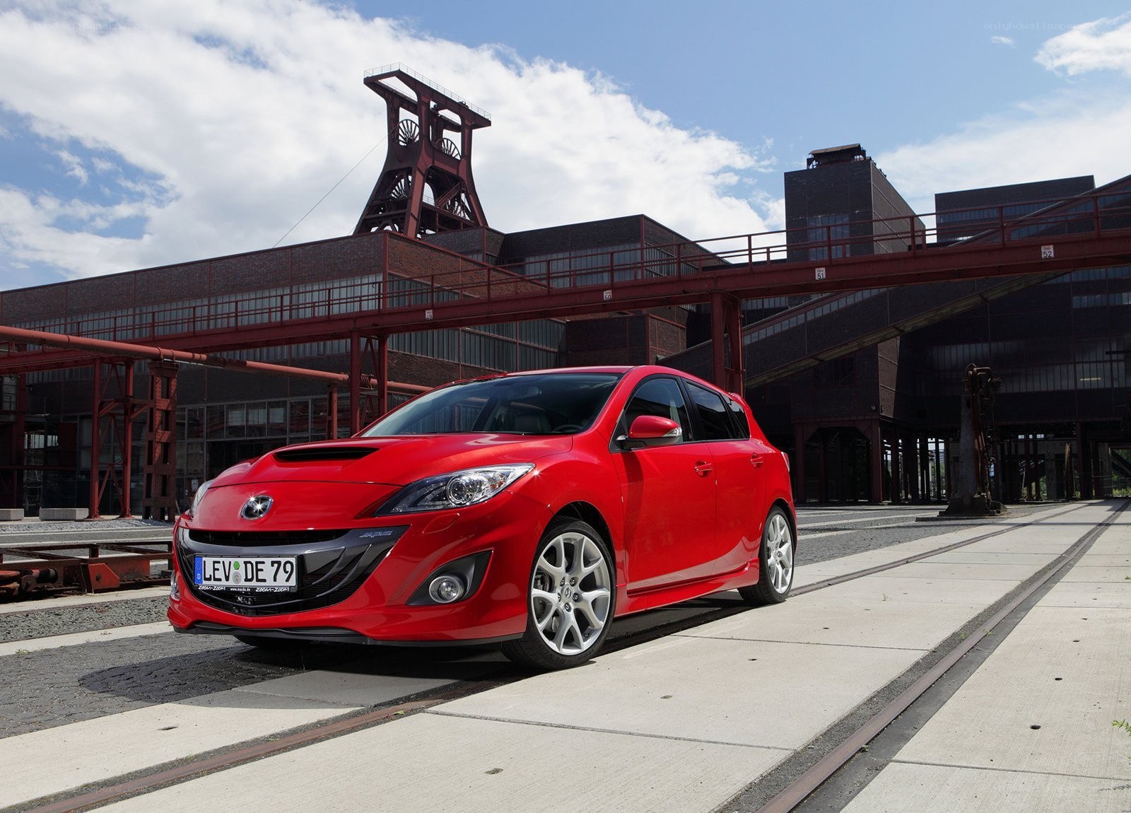 Red Mazda 3 in industrial setting