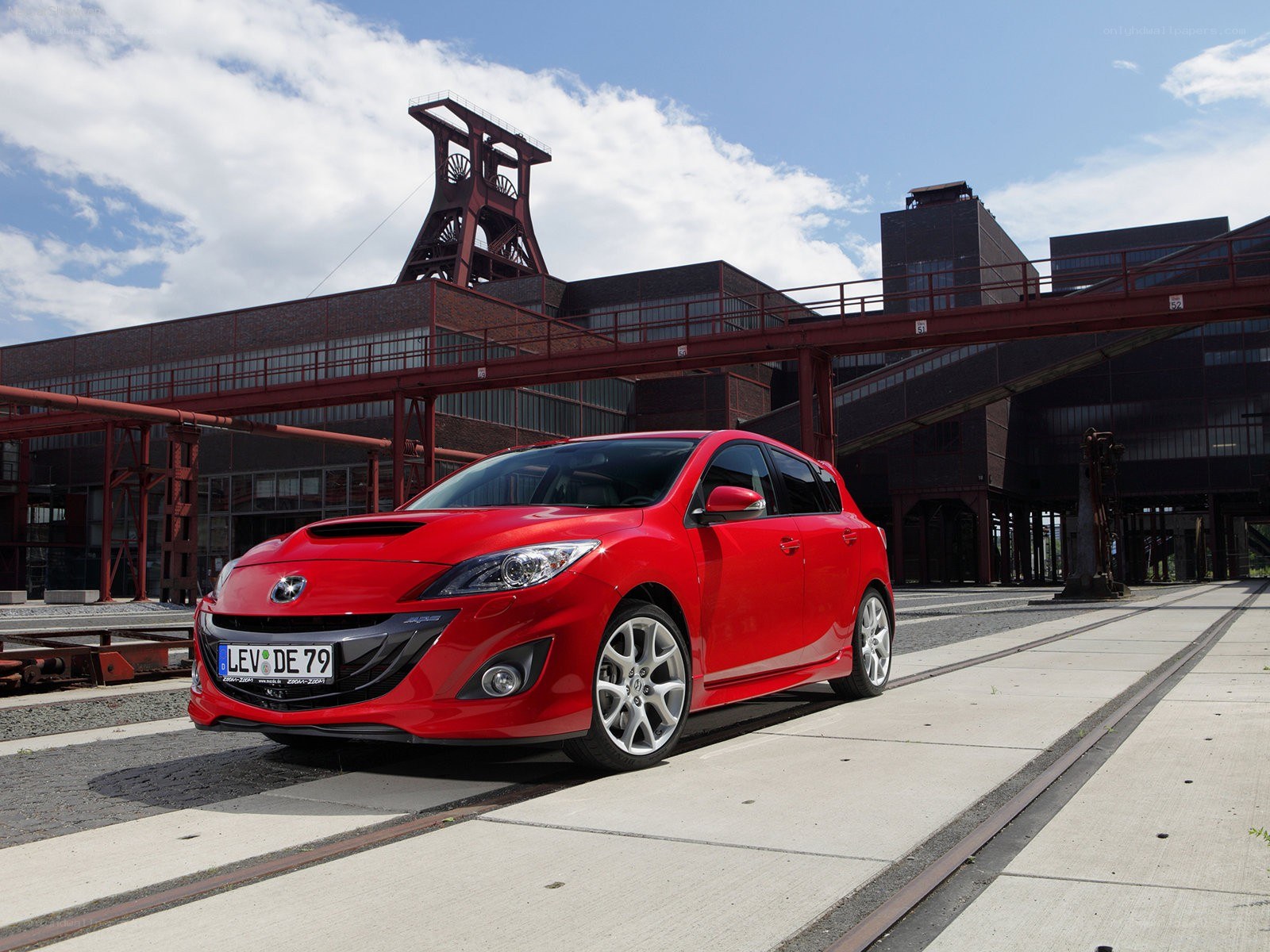 Red Mazda 3 in industrial setting