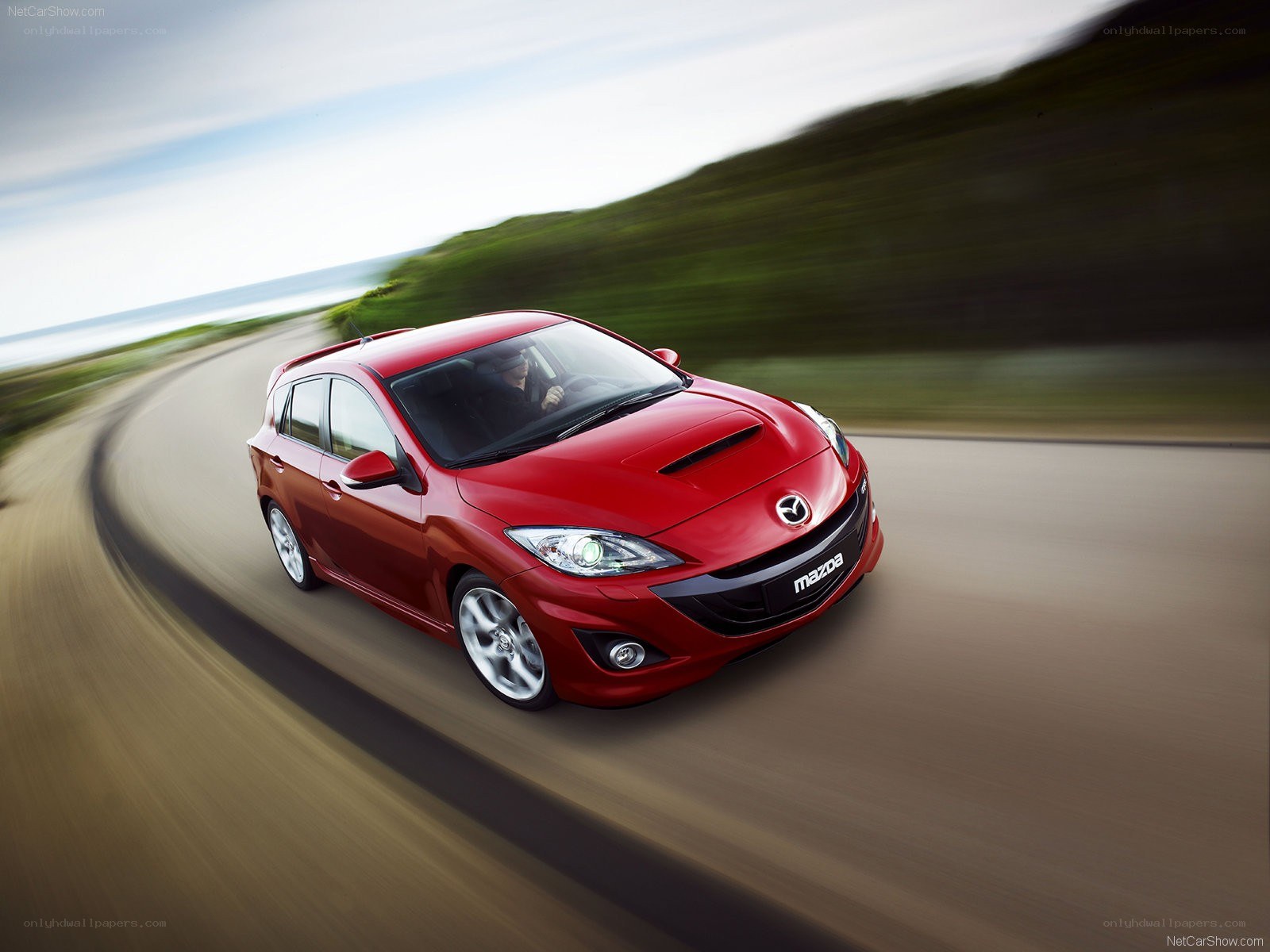 Red Mazda 3 in motion