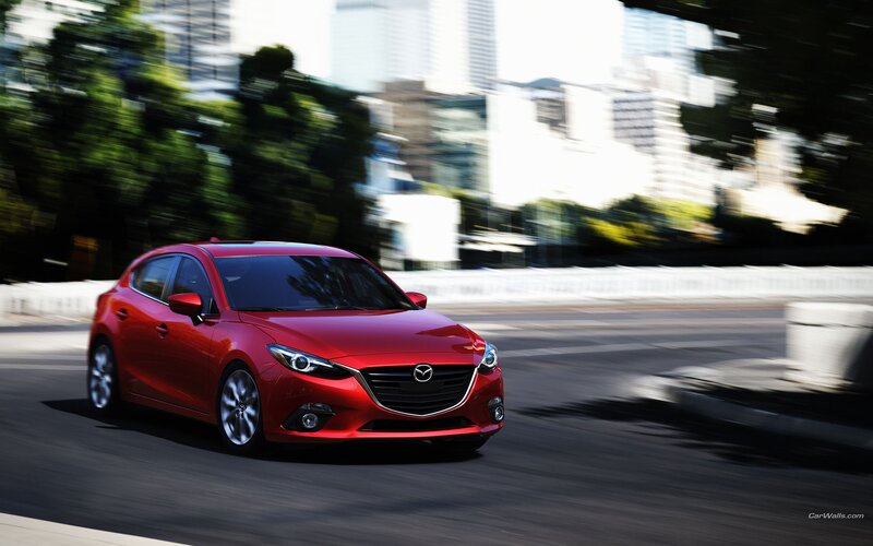 Red Mazda 3 in motion