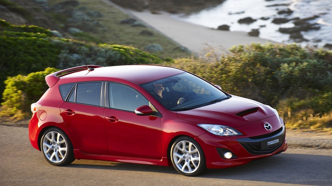 Red Mazda 3 on coastal road