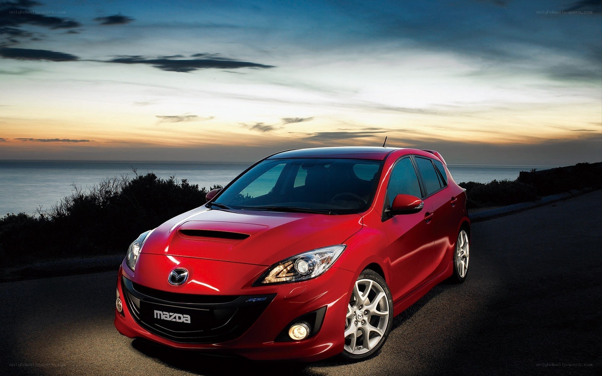Red Mazda 3 on coastal road