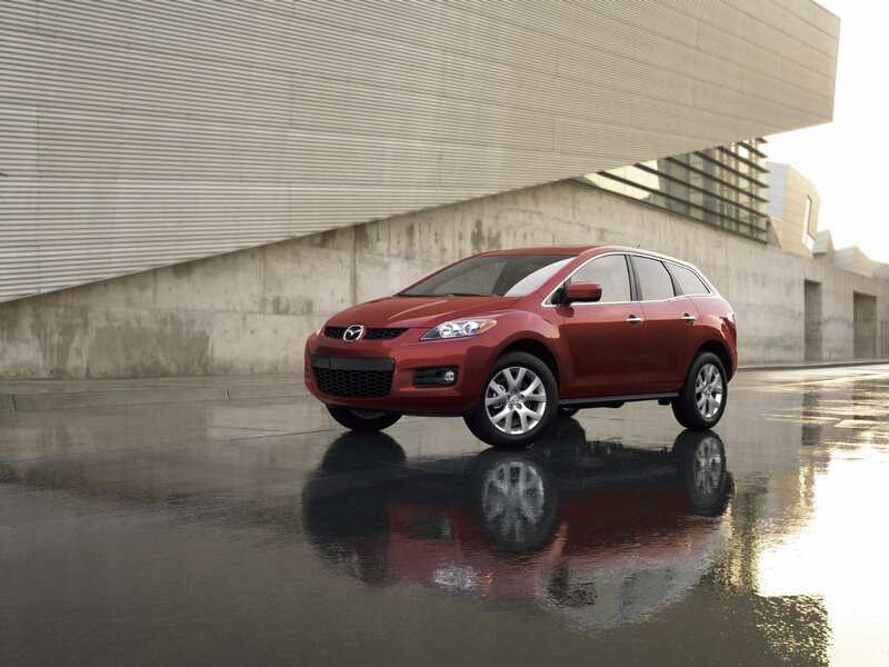 Red Mazda CX-7 parked on wet pavement