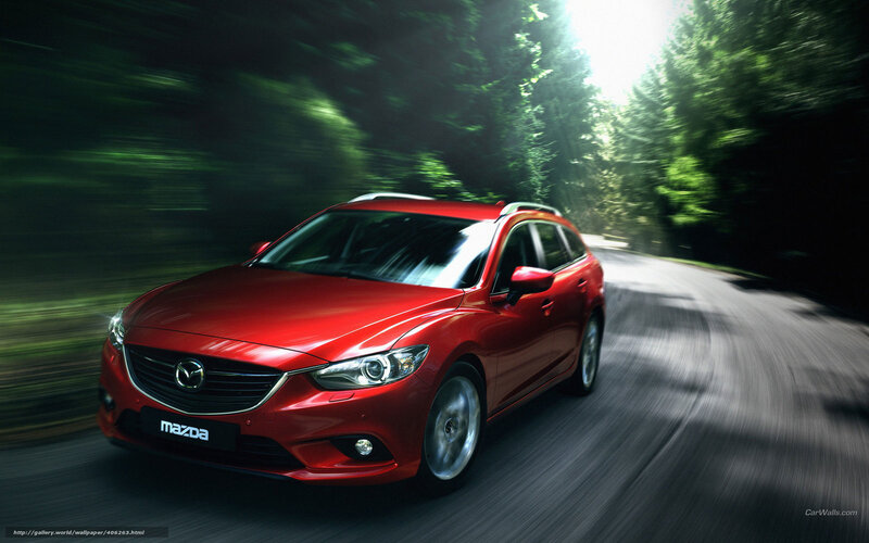 Red Mazda driving on forest road