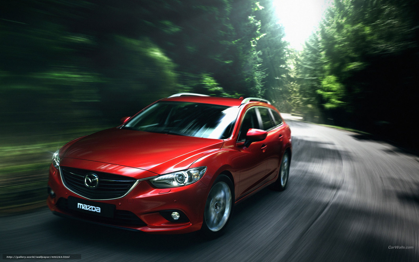 Red Mazda driving on forest road