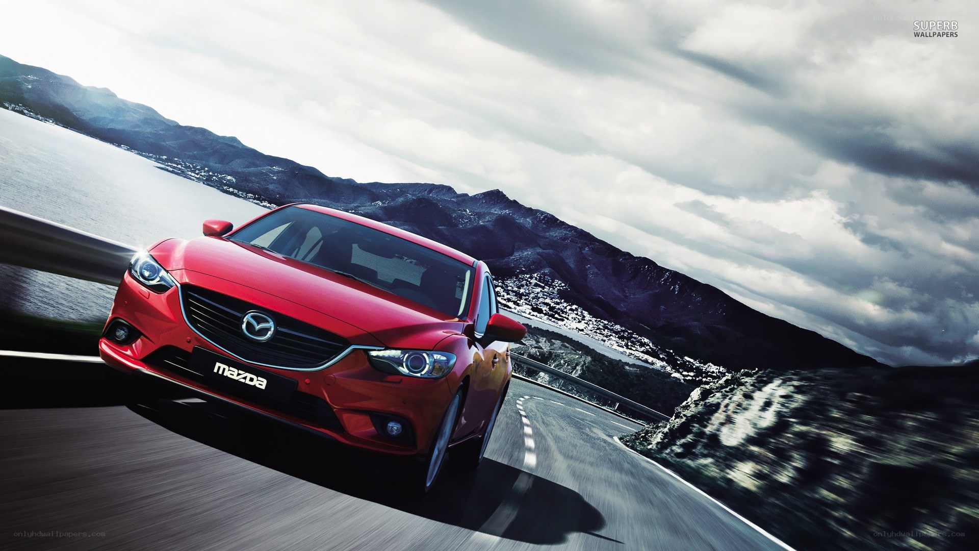 Red Mazda on coastal road
