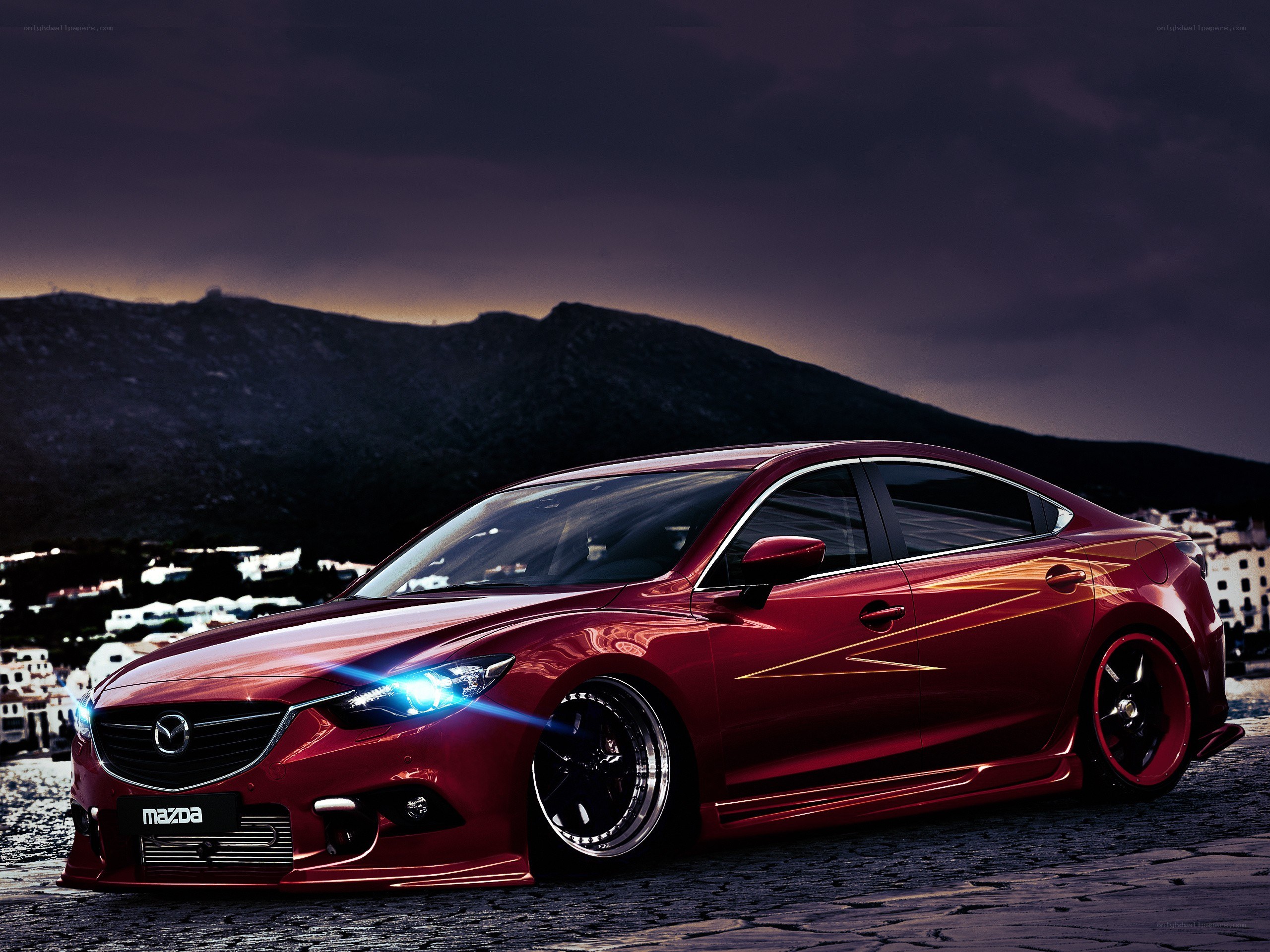 Red Mazda sedan at dusk