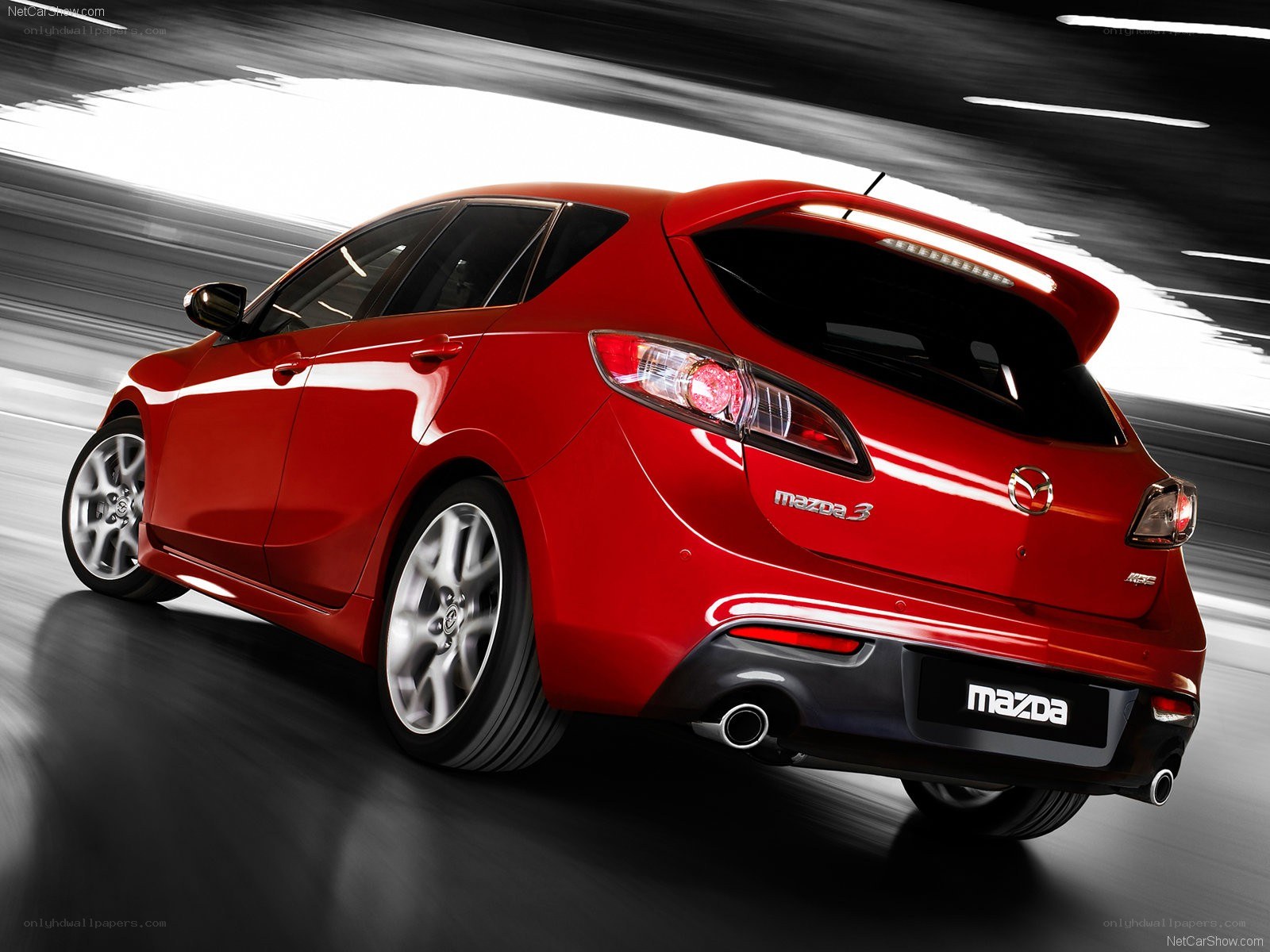 Red Mazda3 hatchback in motion