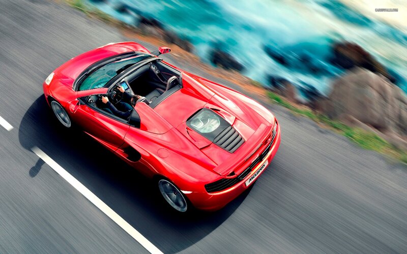 Red McLaren driving on coastal road