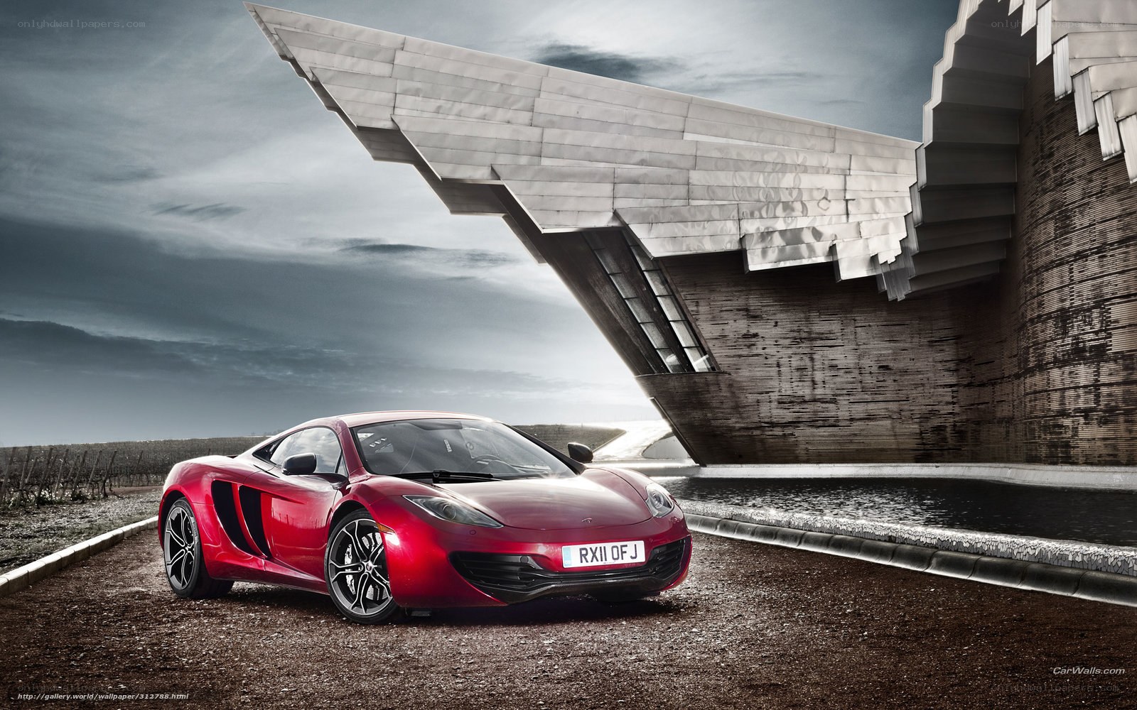 Red McLaren in front of modern building