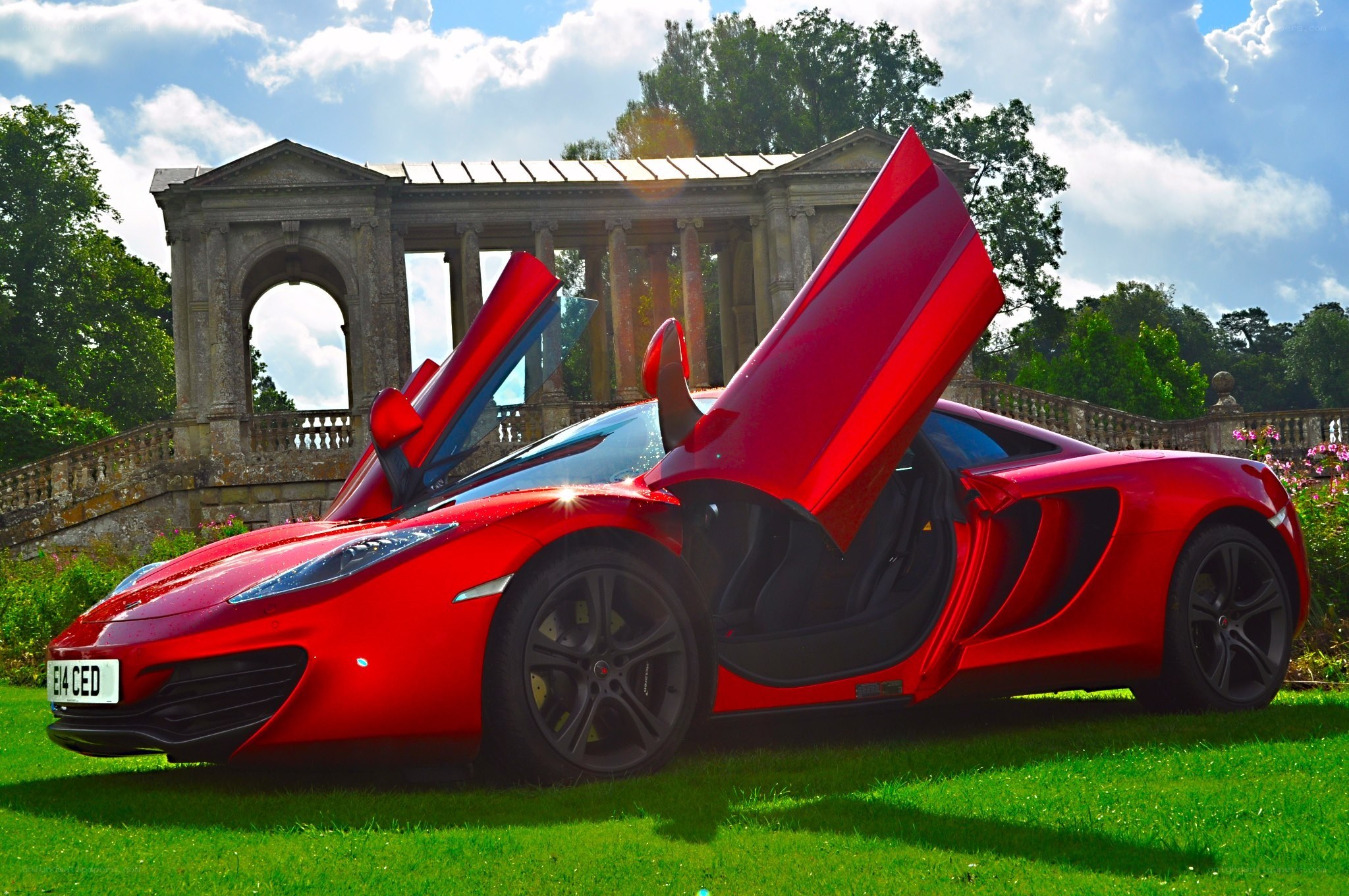 Red McLaren on a green lawn