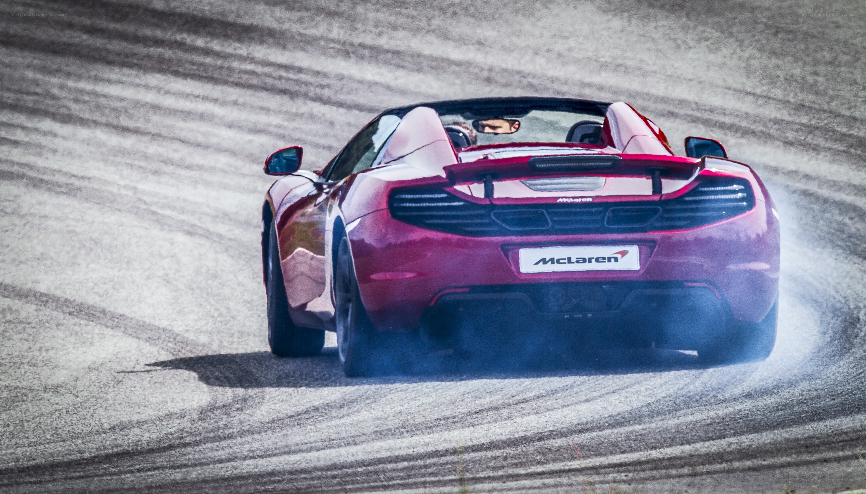 Red McLaren on a racetrack