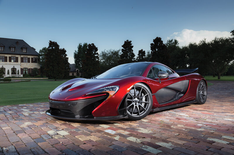 Red McLaren P1 on a brick driveway