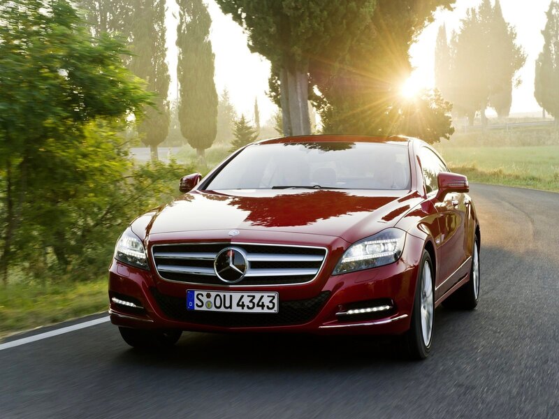 Red Mercedes-Benz CLS driving on country road