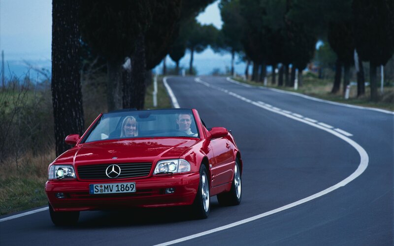 Red Mercedes-Benz convertible on a winding road