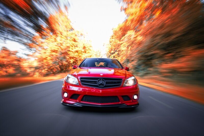 Red Mercedes driving on autumn road