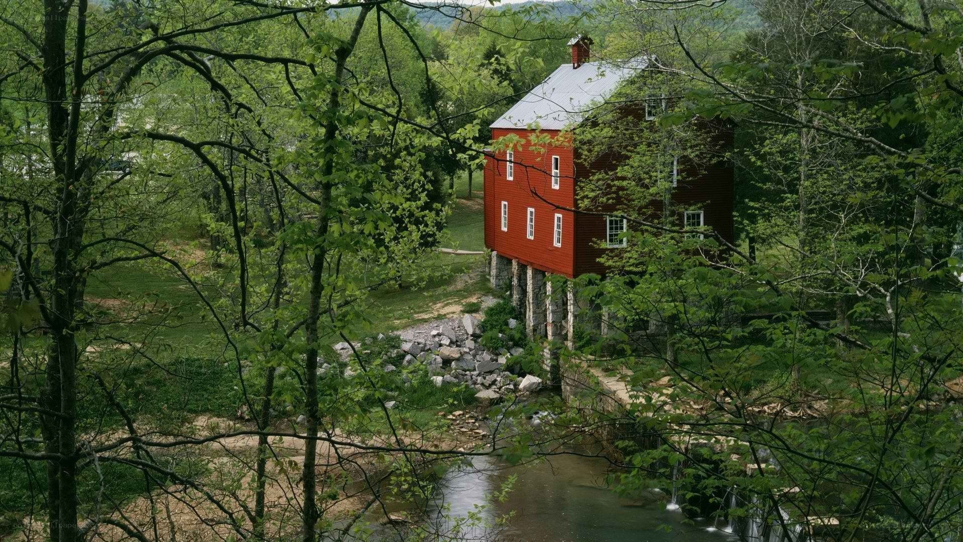 Red mill by a forest stream