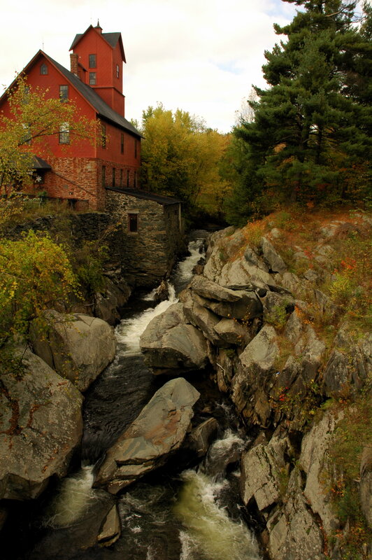 Red mill by a rocky stream