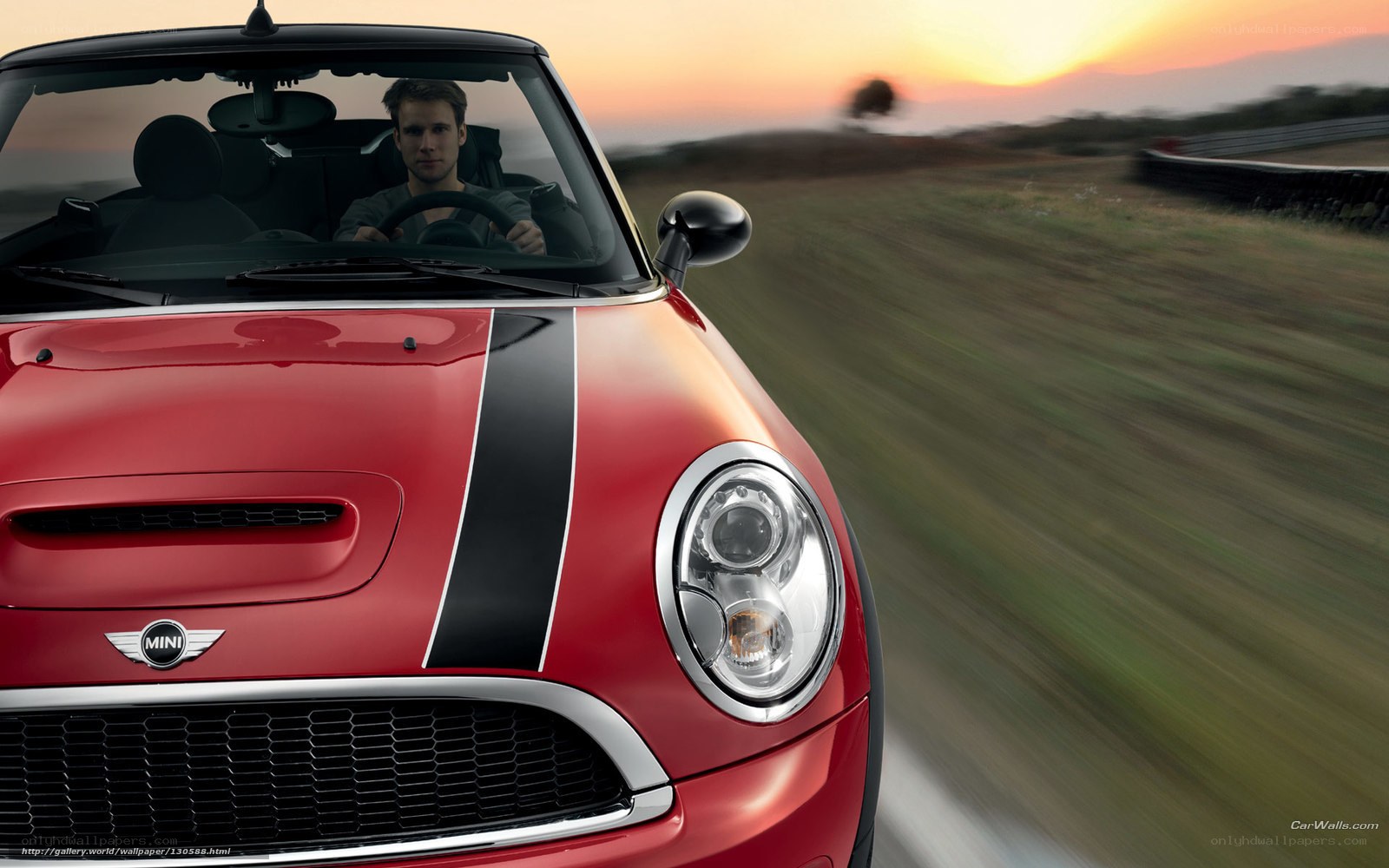 Red MINI driving at sunset