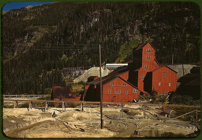 Red mining buildings in forested valley