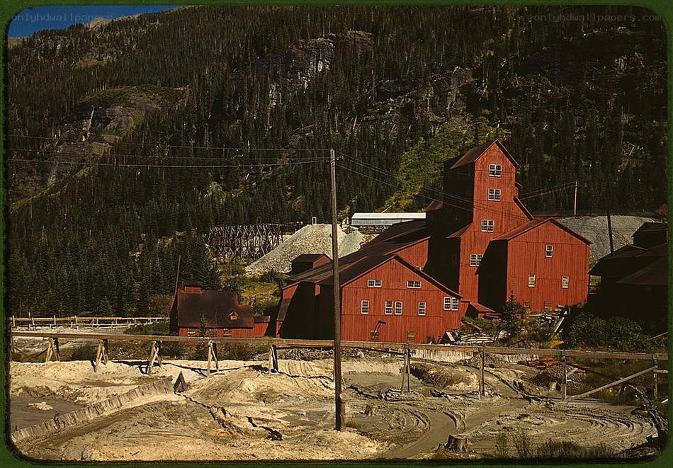 Red mining buildings in forested valley