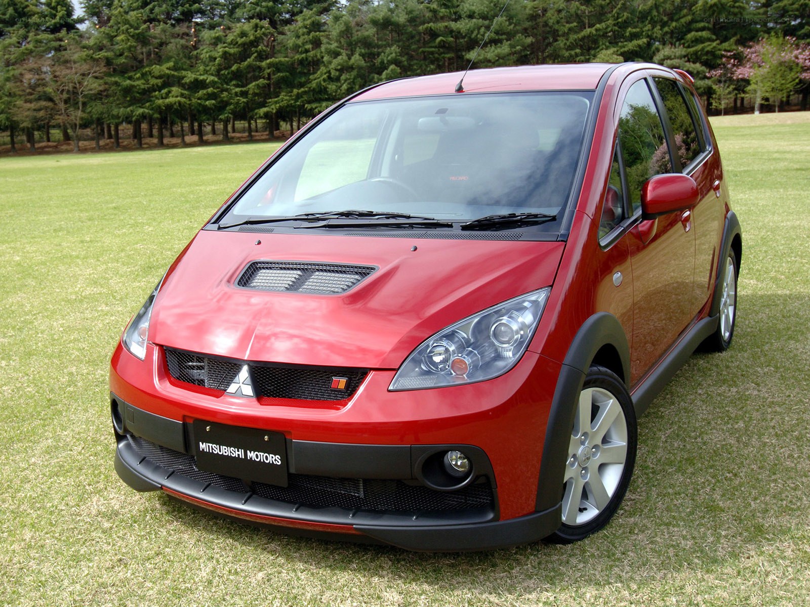 Red Mitsubishi car on grass
