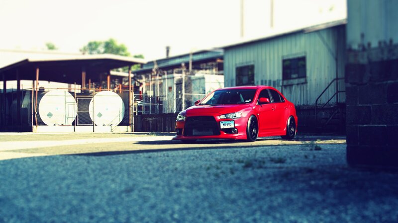 red mitsubishi evo in industrial lot