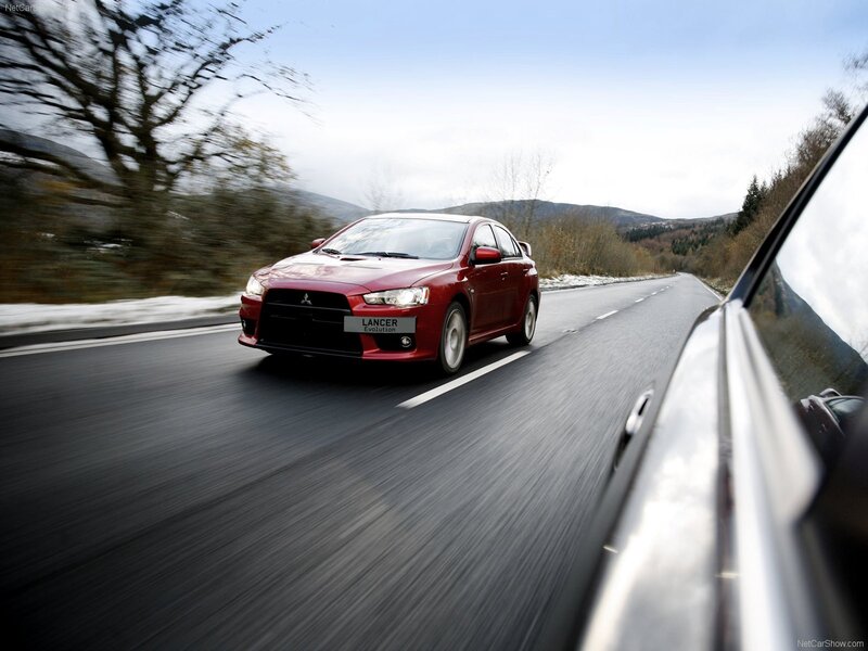Red Mitsubishi Lancer Evolution on a road