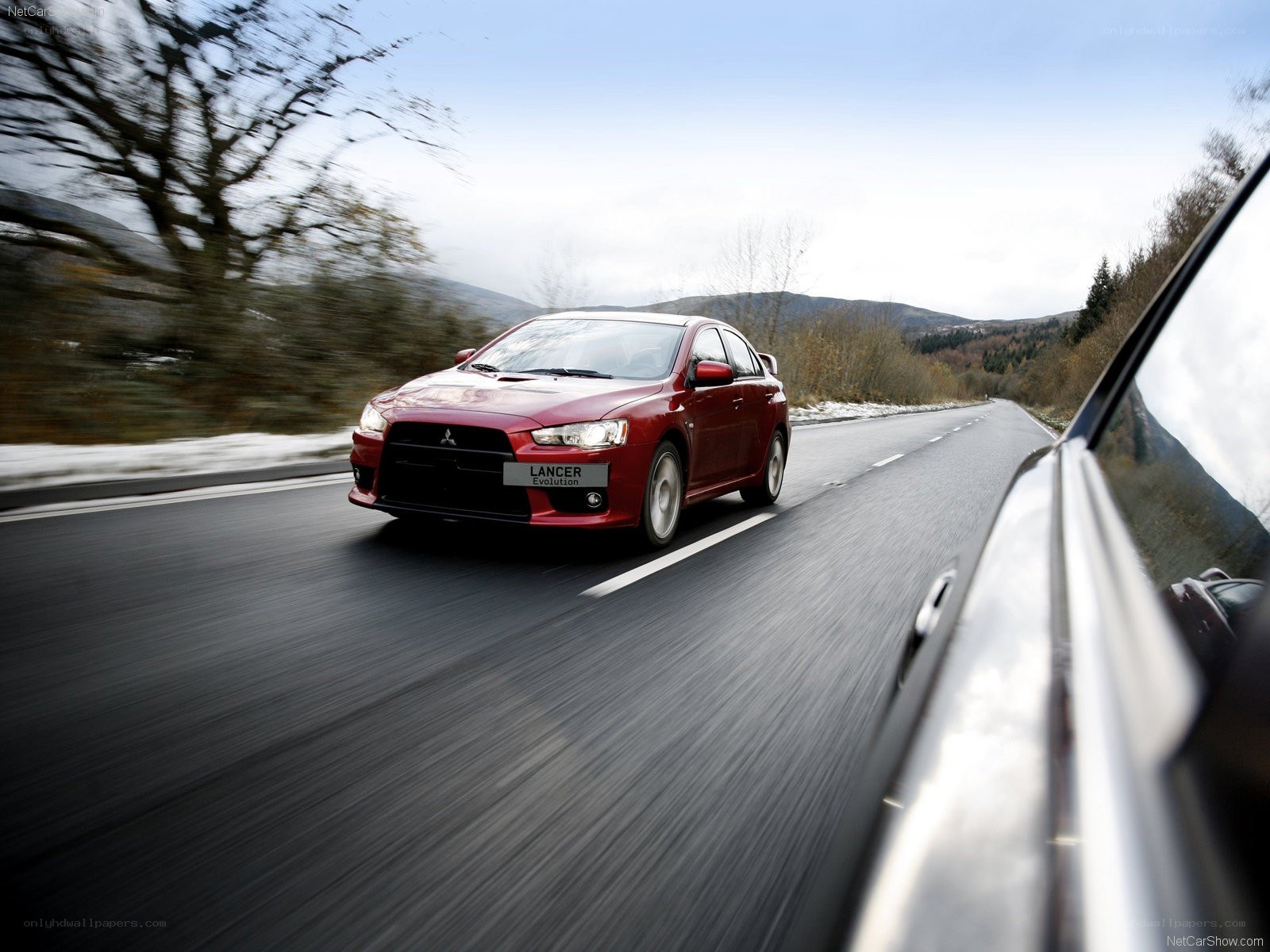 Red Mitsubishi Lancer Evolution on a road