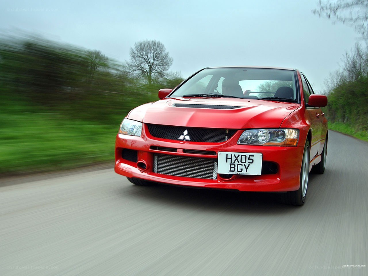 Red Mitsubishi Lancer Evolution on road