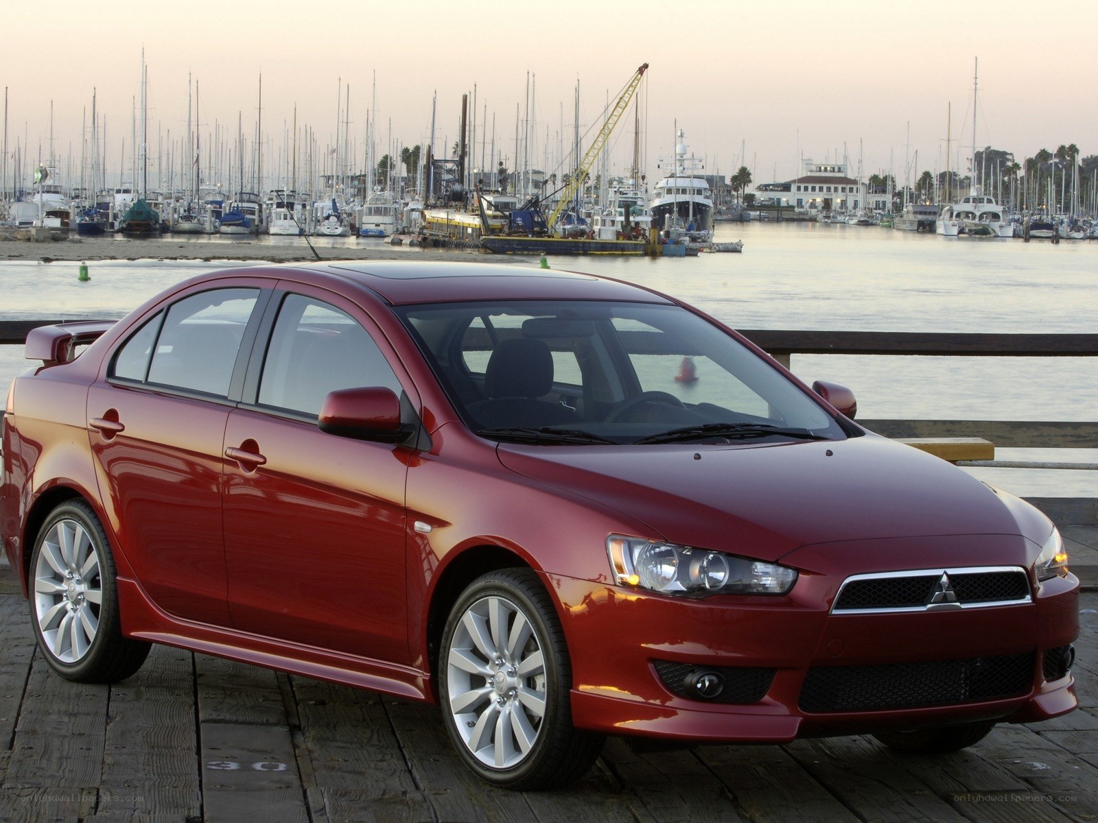 Red Mitsubishi Lancer on a dock