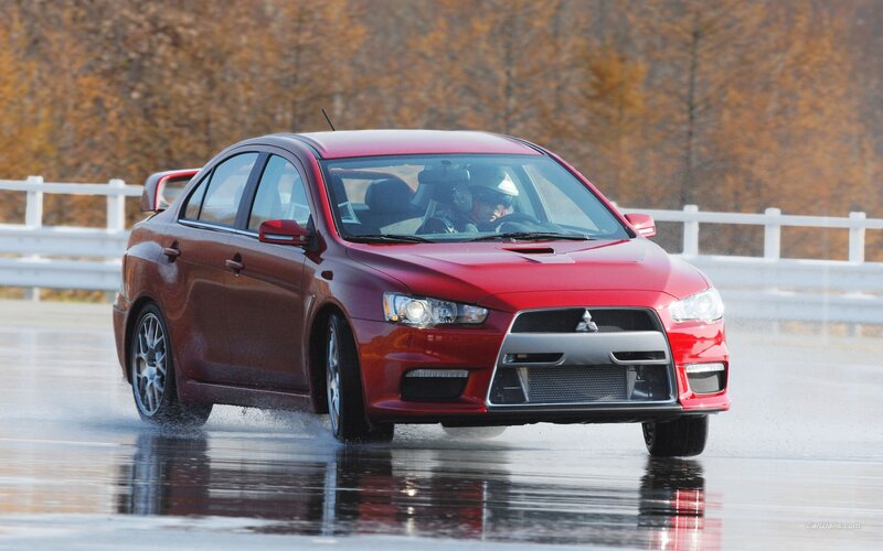 Red Mitsubishi Lancer on wet track