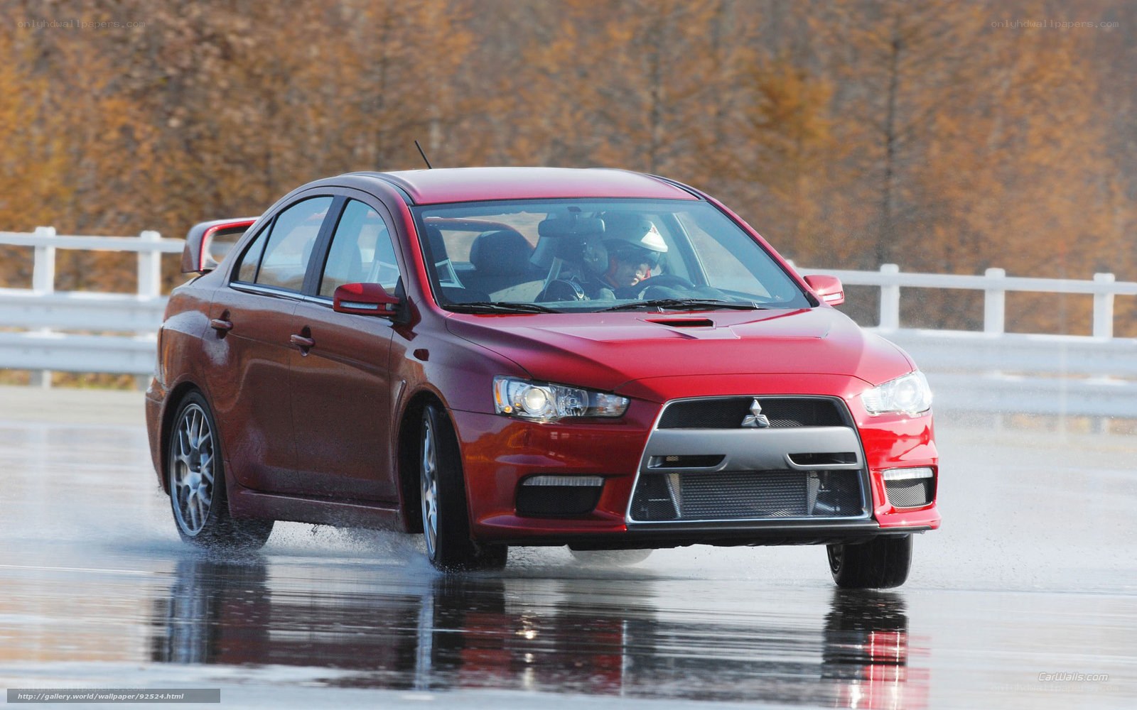 Red Mitsubishi Lancer on wet track