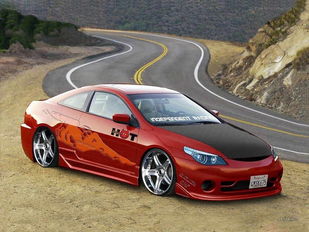 Red modified coupe on winding road