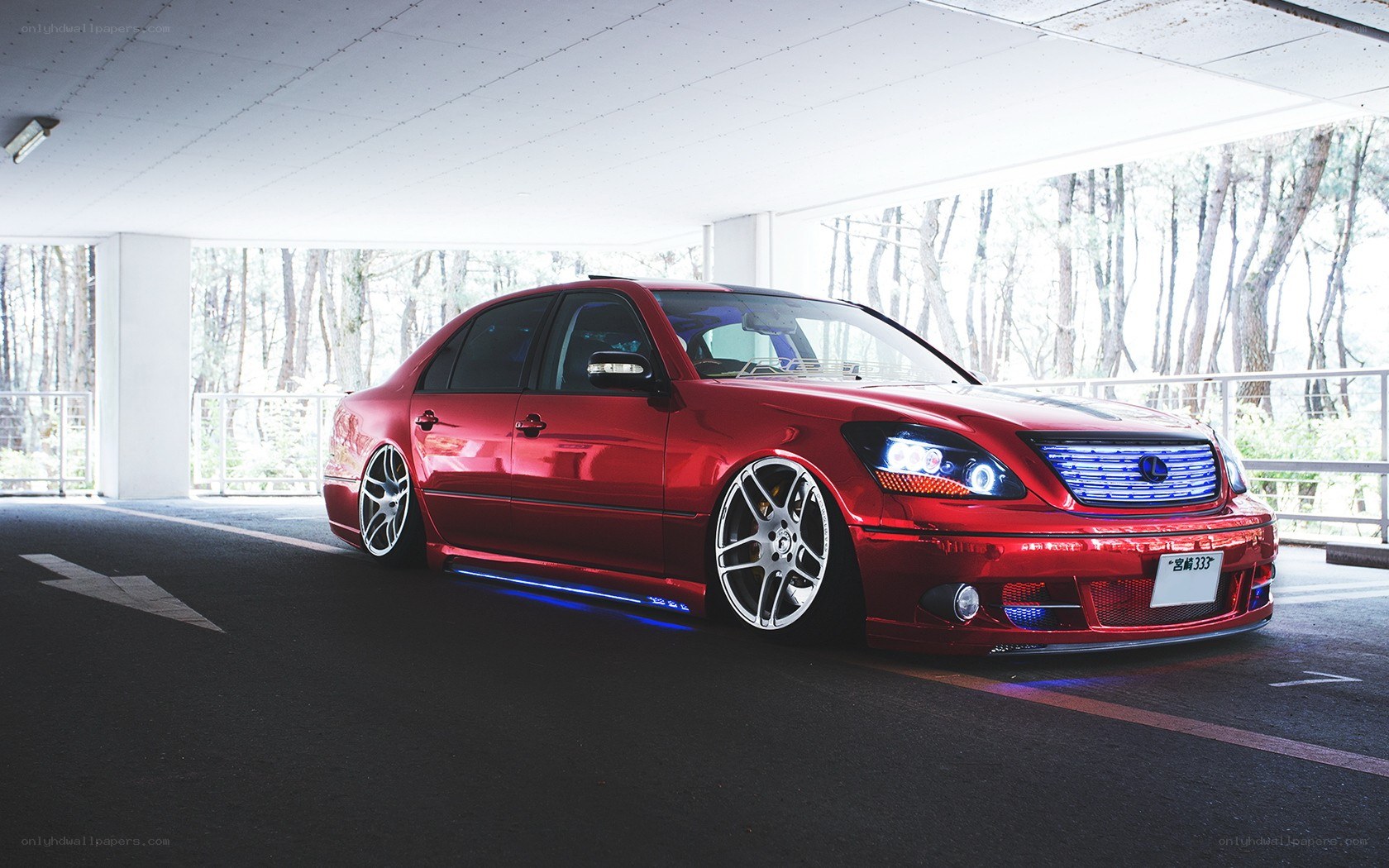 Red modified sedan in parking garage