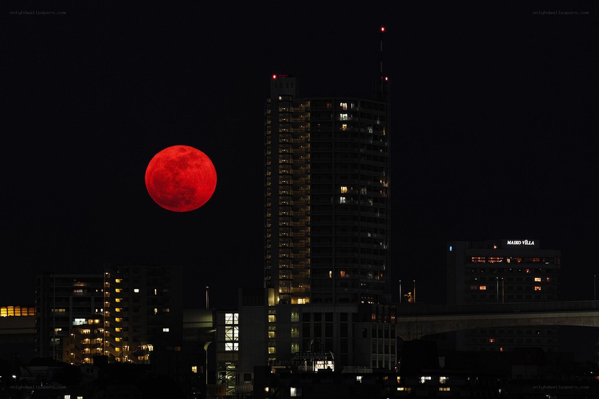 Red moon over city skyline