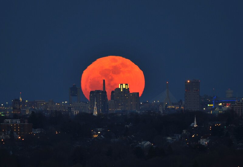 Red moon over city skyline