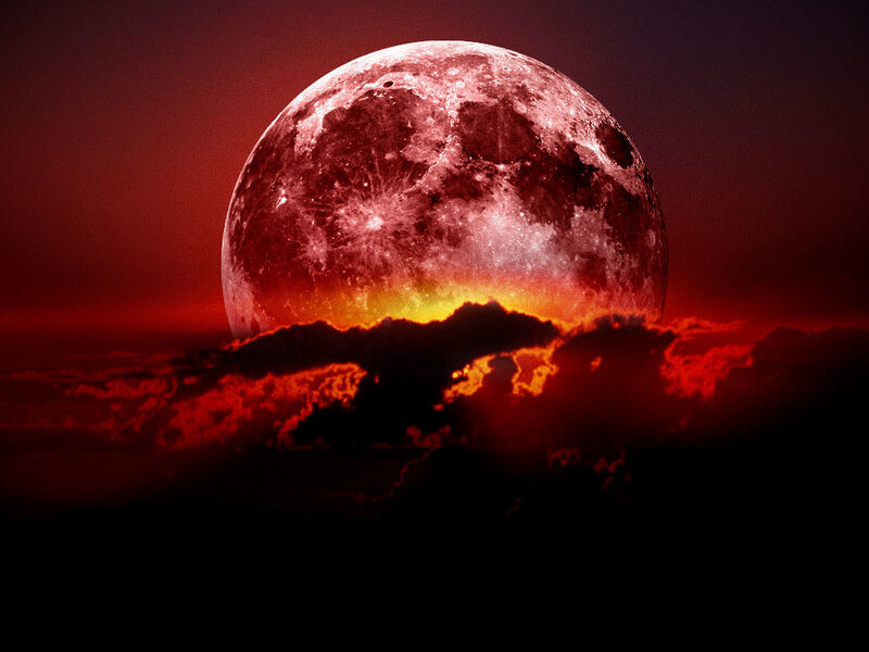 Red moon rising over clouds