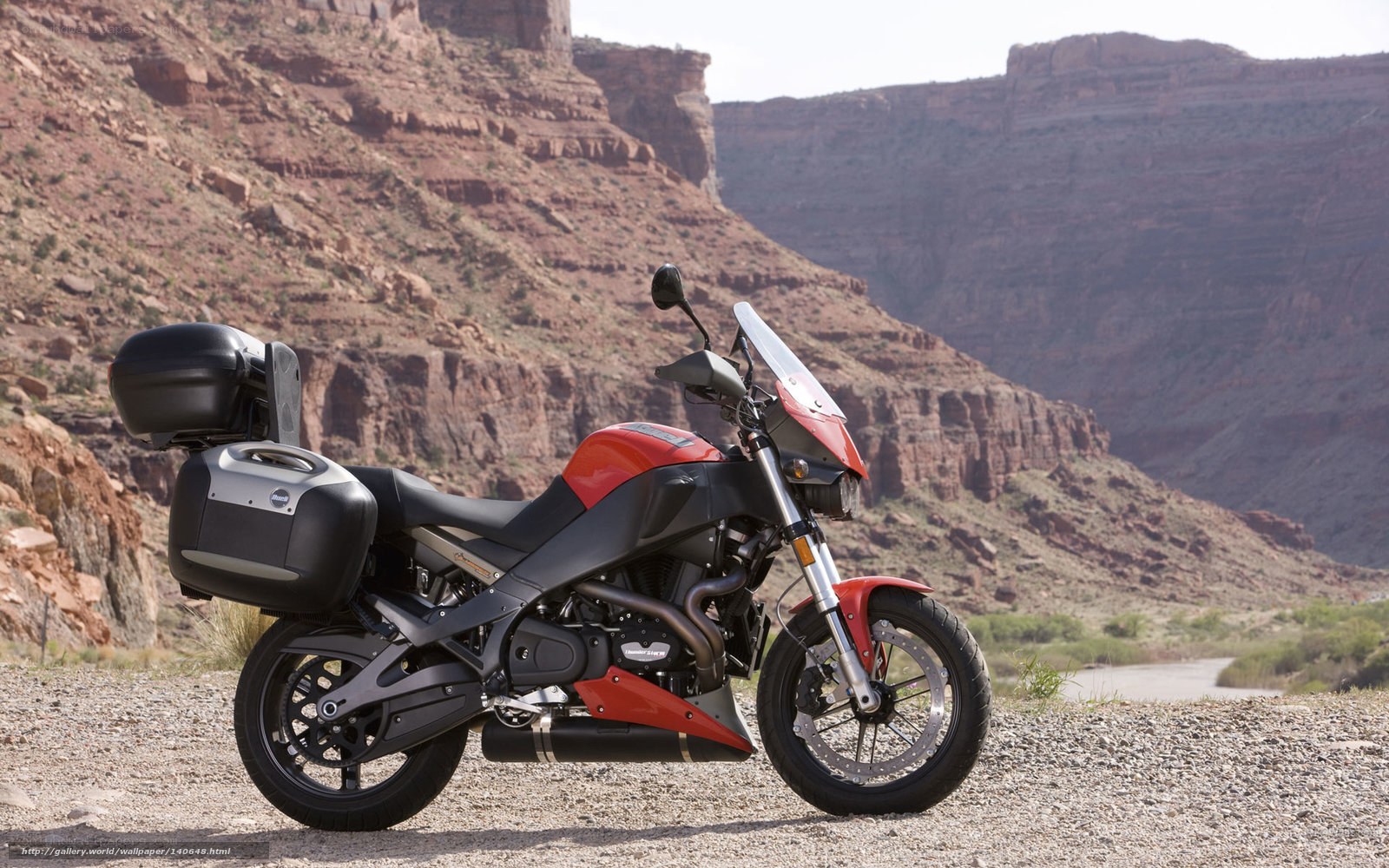 Red motorcycle in desert canyon