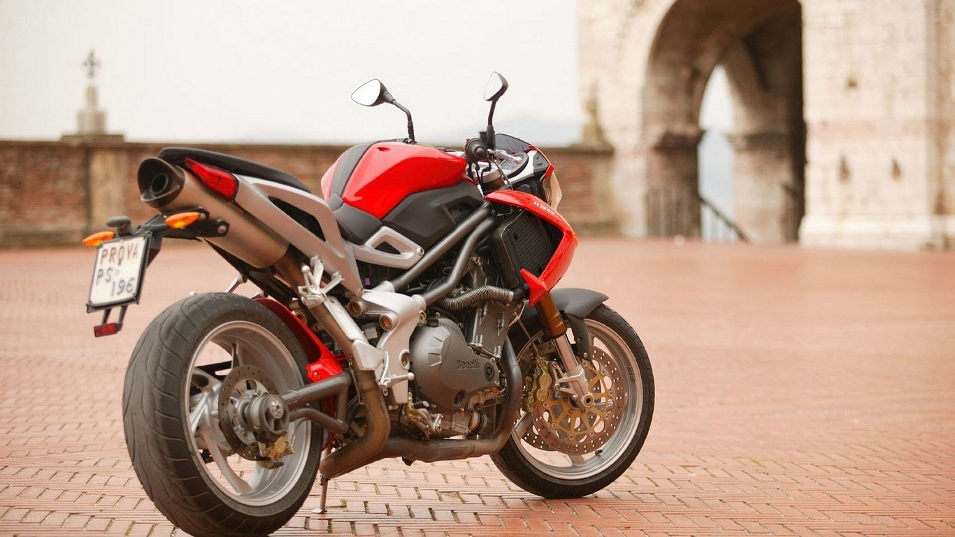Red motorcycle on brick pavement