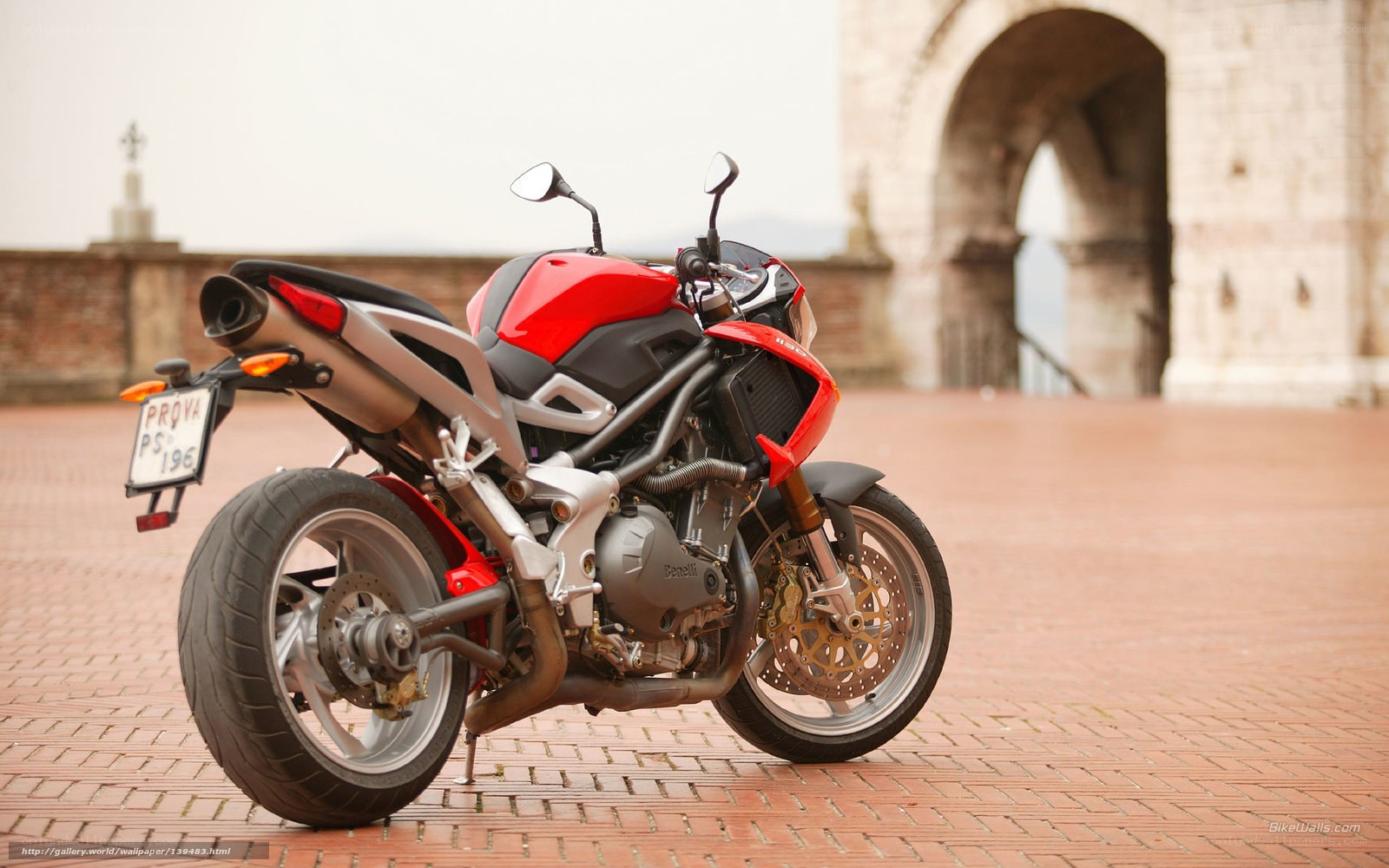 Red motorcycle on brick pavement
